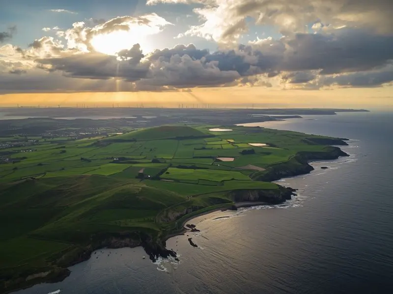 Aerial view of Northern Ireland's diverse landscape featuring agricultural land, wind farms, and coastline representing the region's environmental challenges and opportunities